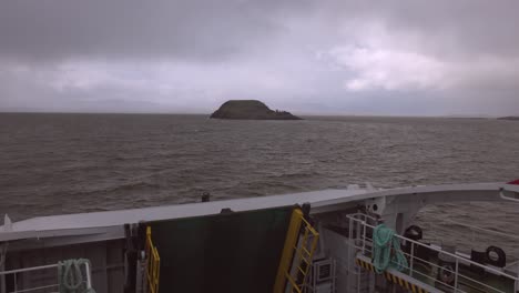 Slow-dolly-shot-towards-a-small-island-off-the-coast-of-Scotland-from-a-small-ferry