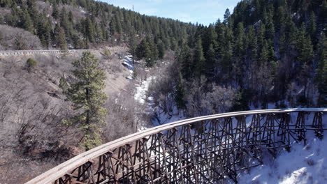 Drone-shot-flying-back-revealing-a-historic-narrow-gauge-truss-railway-in-the-New-Mexico-Mountains-near-Cloudcroft