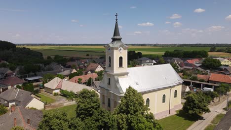 Aerial-parallax-around-small-neighborhood-church-in-Batya,-Hungary