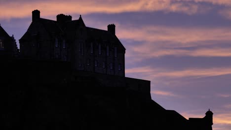 Silhouette-of-close-section-of-Edinburgh-Castle-at-sunset-on-a-winter's-night,-Scotland