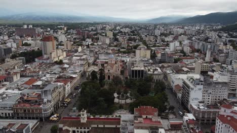 Flat-light-aerial-orbits-July-9-Square,-cathedral-in-Salta-Argentina