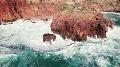 Vista-Aérea-De-Un-Círculo-De-Drones-De-4k-De-Grandes-Olas-Rompiendo-En-La-Costa-De-Un-Acantilado-Escondido-De-Praia-Da-Zimbreirinha-Cerca-De-Fronteraira-En-La-Región-Del-Algarve-De-Portugal