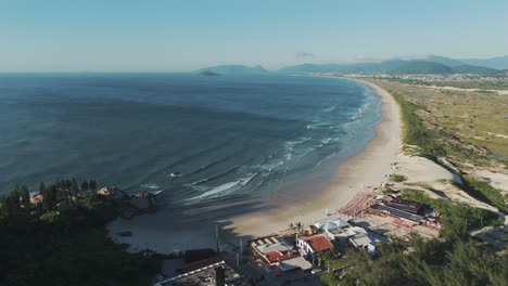 Drone-advancing-over-the-beautiful-Joaquina-Beach-in-Florianópolis,-Brazil,-on-a-sunny-morning