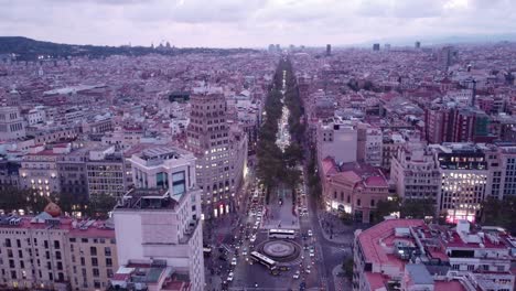 Barcelona-In-Der-Abenddämmerung-Mit-Den-Lichtern-Der-Stadt,-Die-Zu-Leuchten-Beginnen,-Verkehr-Auf-Den-Straßen,-Luftaufnahme