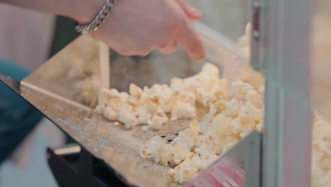 Frisch-Geschöpftes-Popcorn-Quillt-Aus-Einer-Metallschaufel,-Ein-Klassischer-Snack-In-Der-Herstellung