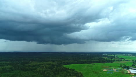 Dramatischer-Himmel-Mit-Regenwolken-über-Wald-Und-Feldern