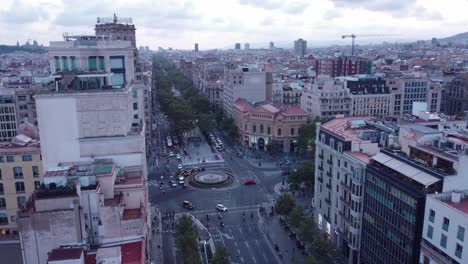 A-bustling-barcelona-intersection-with-cars-and-pedestrians,-overcast-day,-aerial-view