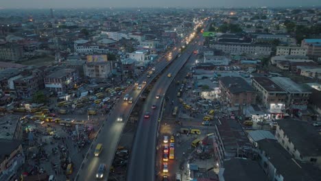 Captivating-aerial-shot:-Evening-lights-dance-as-vehicles-glide-over-Lagos-bridge,-a-mesmerizing-urban-symphony-captured-in-motion
