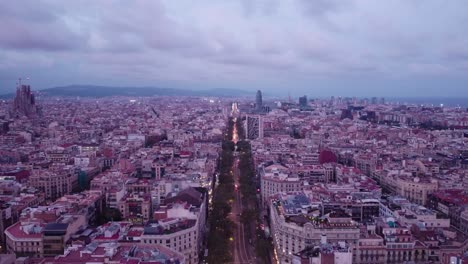 Barcelona-In-Der-Abenddämmerung-Mit-Den-Lichtern-Der-Stadt,-Die-Zu-Leuchten-Beginnen,-Luftaufnahme