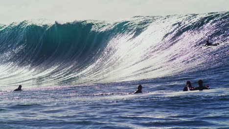 Vibrante-Agua-Azul-Profunda-Del-Océano-De-Una-Enorme-Ola-Monstruosa-Mientras-El-Surfista-Levanta-Los-Brazos