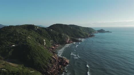 Una-Impresionante-Vista-Aérea-Captura-La-Belleza-Escarpada-De-La-Costa-Rocosa-De-Joaquina,-Donde-El-Poderoso-Océano-Atlántico-Se-Encuentra-Con-La-Tierra,-Creando-Una-Fascinante-Vista-De-Esplendor-Natural.