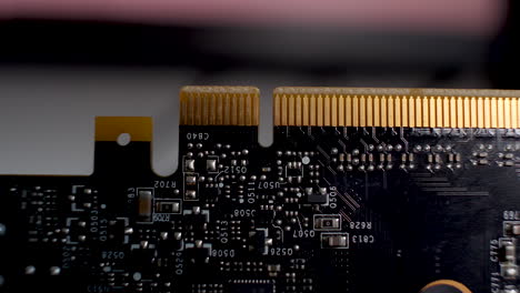 Close-up-of-a-graphics-card,-the-PCB-with-its-array-of-yellow-pin-connectors-which-seamlessly-integrate-with-motherboards,-embodying-the-concept-of-technological-synergy-and-hardware-integration
