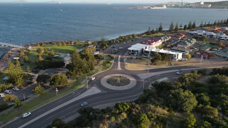 Toma-Aérea-De-Establecimiento-De-Una-Rotonda-En-La-Costa-De-La-Ciudad-De-Esperance-Durante-La-Puesta-De-Sol-Dorada,-Australia-Occidental