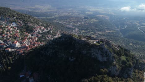 Órbita-Aérea-De-Alto-ángulo-Sobre-El-Castillo-De-Karytaina-Al-Mediodía-Con-El-Pueblo-Y-El-Valle-Al-Fondo