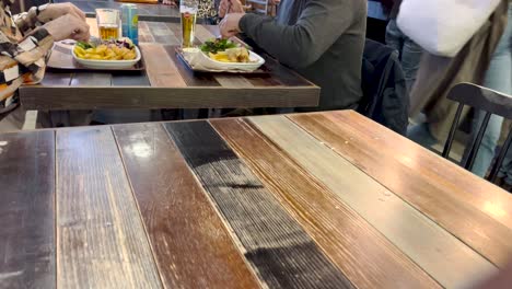 Two-people-eating-fish-fries-with-beer-at-casual-restaurant