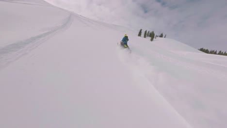 Aerial-FPV-Following-Snowmobile-Rider-Across-Snow-Covered-Sharkstooth-Peak-Landscape-In-Colorado