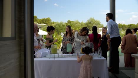 Guests-at-outdoor-Arab-wedding-enjoy-refreshments,-laughter-filling-the-air