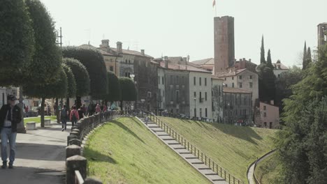 People-On-Historic-Viale-dei-Martiri-With-View-Of-Tower-Of-Ser-Ivano-In-Bassano-del-Grappa,-Italy