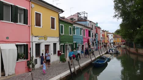 Los-Turistas-Caminan-Por-Casas-Coloridas-Tradicionales-De-Gira-En-Burano,-Venecia.