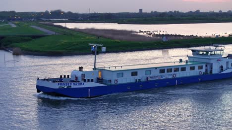 Ship-Prinses-Maxima-Cruising-River-In-Alblasserdam,-Netherlands---Drone-Shot