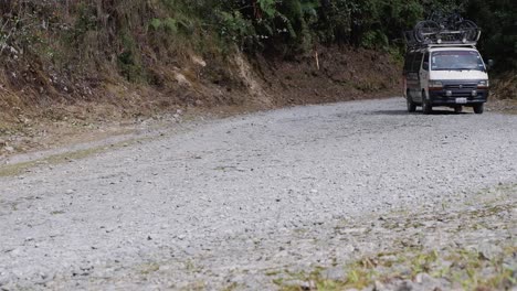 Tour-van-follows-cyclists-riding-down-Yungas-mountain-road-in-Bolivia