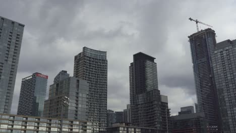 Downtown-Toronto-High-Rise-Skyline,-Crane-Moving-On-Construction-Site