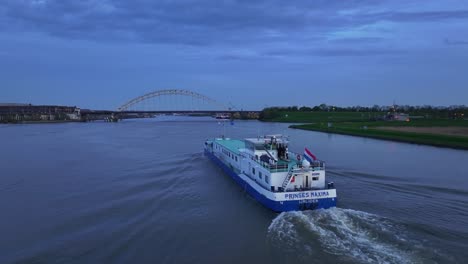 Aerial-View-Of-Prinses-Máxima-Ship-Cruising-Through-The-River-At-Sunset-In-Alblasserdam,-Netherlands---Drone-Shot