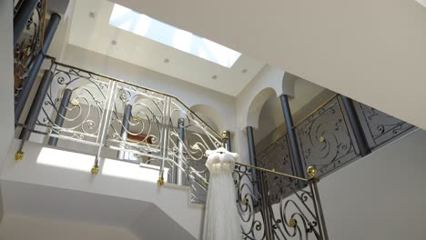 Scenic-bridal-wedding-dress-shot-inside-hallway-with-stairs-and-glass-roof-window