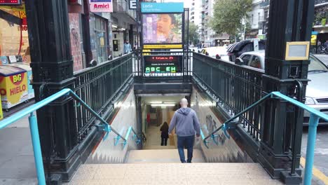 Hombre-Blanco-Camina-Rápido-Hacia-La-Entrada-Del-Metro-Bulliciosa-Calle-De-La-Ciudad-Latina-De-Buenos-Aires,-Transporte-Público-En-La-Avenida-Rivadavia