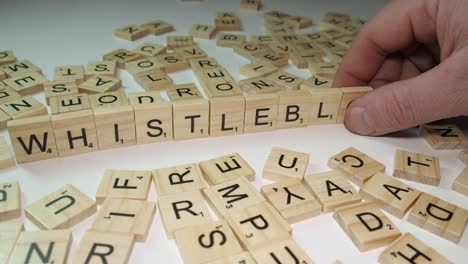 Legal-term-WHISTLEBLOWER-formed-with-Scrabble-letter-tiles-on-table