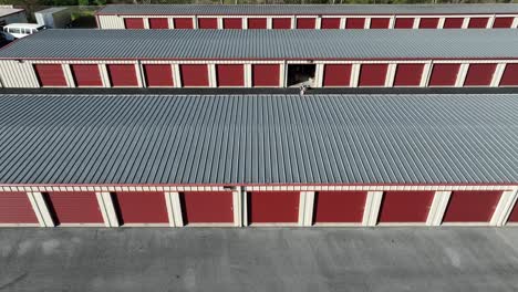 Person-leaving-Self-Storage-Unit-Garage-in-red-color-during-sunny-day