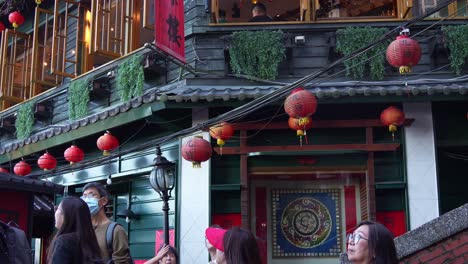 A-Mei-teahouse-at-Jiufen-Old-Street,-lanterns-hanging-around-the-heritage-building-exteriors,-a-gold-mining-mountain-town,-popular-tourist-attraction-in-Taiwan,-handheld-motion-tilt-up-shot