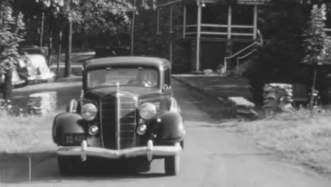 Un-Coche-Antiguo-Circula-Por-Una-Calle-Suburbana-A-La-Luz-Del-Día-De-1930-En-Bw