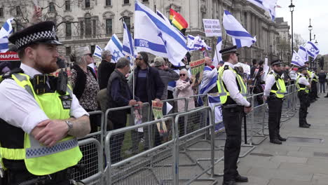 Beamte-Der-Metropolitan-Police-Bilden-Einen-Kordon-Vor-Pro-israelischen-Demonstranten,-Die-Plakate-Und-Wehende-Fahnen-Während-Einer-Gegendemonstration-Zur-Jährlichen-Demonstration-Zum-Al-Quds-Tag-Halten