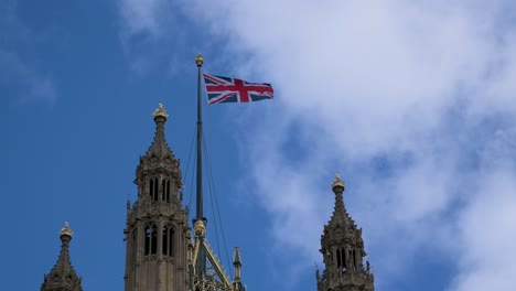 The-Union-Jack,-Flag-of-Great-Britain-waving-in-the-wind-on-the-tower-of-Palace-of-Westminster,-Houses-of-Parliament-in-London,-England---March-2024