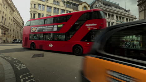 Tour-Bus,-cars,-taxis-rounds-corner-onto-The-Haymarket,-London,-Day