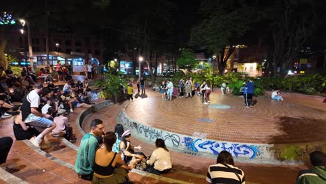 Bustling-nighttime-scene-at-El-Poblado,-Medellin-with-locals-enjoying-outdoor-seating-and-vibrant-street-life