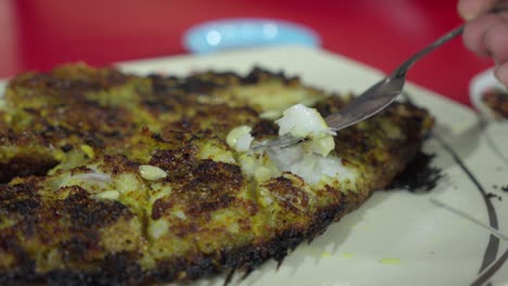 Primer-Plano-De-Pescado-A-La-Parrilla-Desmenuzado-Con-Un-Tenedor,-Servido-En-Un-Plato,-Experiencia-Gastronómica,-En-El-Interior