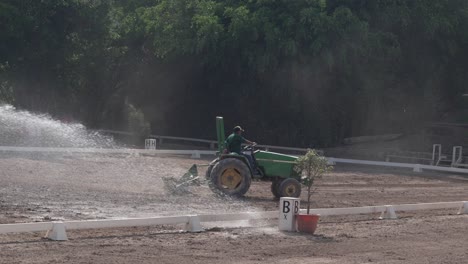 Man-drives-a-tractor-working-on-preparing-the-arena-at-equestrian-competition-club,-Tegucigalpa,-Honduras