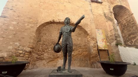 The-statue-honoring-Juan-Relinque,-nestled-near-the-Puerta-de-Sancho-IV-in-Vejer-de-la-Frontera,-Cádiz,-Spain,-showcases-the-rich-history-and-heritage-of-the-region