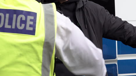 A-police-officer-searches-a-man-wearing-a-black-T-shirt-that-reads,-“Hamas-are-terrorists”-during-an-arrest-at-protests-during-the-annual-Al-Quds-day-demonstration