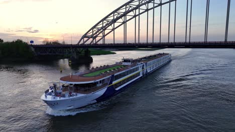 Monarch-Queen-Ship-Sailing-Across-The-River-In-Hendrik-Ido-Ambacht,-Netherlands---Aerial-Drone-Shot