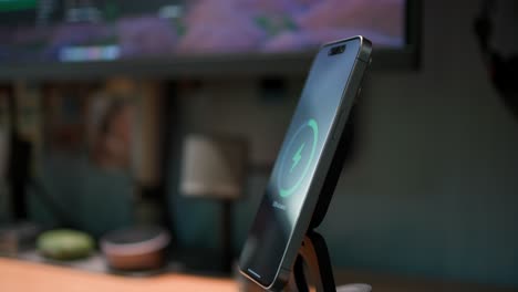 A-hand-places-a-black-smartphone-on-a-desktop-wireless-charging-stand