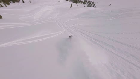 Schneemobilfahrer-Springt-Mit-FPV-Luftaufnahmen-Vom-Hang-Und-Folgt-Ihm-Auf-Dem-Sharkstooth-Peak,-Colorado