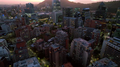 Dusk-settles-over-Santiago's-affluent-El-Golf-area,-city-lights-awakening