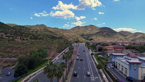 Drone-Flying-Over-Outgoing-Traffic-in-Lake-Elsinore-California-over-Railroad-Canyon-Road-Clouds-in-Distance-shadows-on-hills