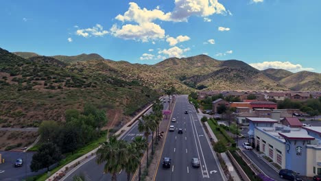 Drone-Volando-Sobre-El-Tráfico-Saliente-En-El-Lago-Elsinore-California-Sobre-El-Cañón-Del-Ferrocarril-Nubes-De-Carretera-En-Sombras-Distantes-En-Las-Colinas