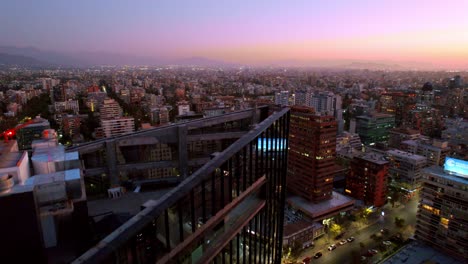 Twilight-hues-over-Santiago-skyline,-glowing-city-lights-begin-to-shine,-serene-urban-sunset