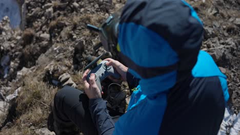 Over-The-Shoulder-View-Of-Man-Wearing-FPV-Drone-Goggles-Holding-Controller