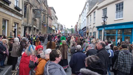 Crowds-of-people-walking-on-the-streets-during-Beltane-May-Day-celebration-in-Glastonbury-town,-Somerset-UK